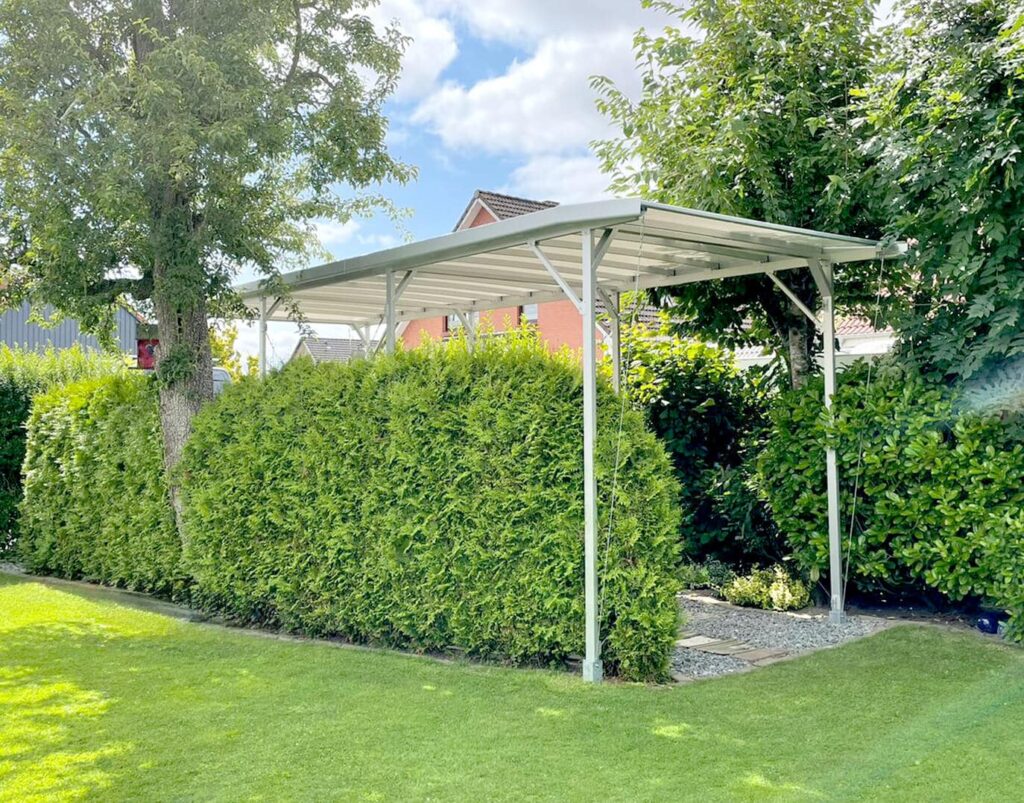 Freistehender Wohnmobil-Carport aus Aluminium vor einer Hecke