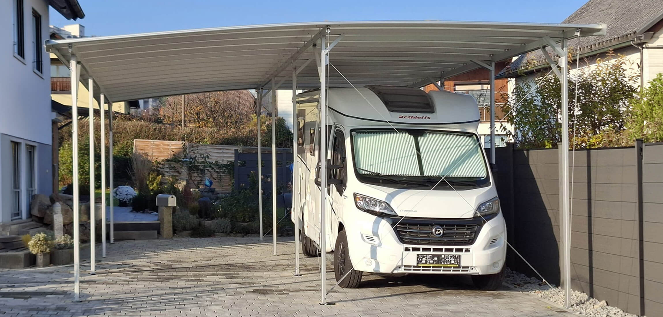Doppelcarport TWINPORT mit Wohnmobil vor einem Wohnhaus